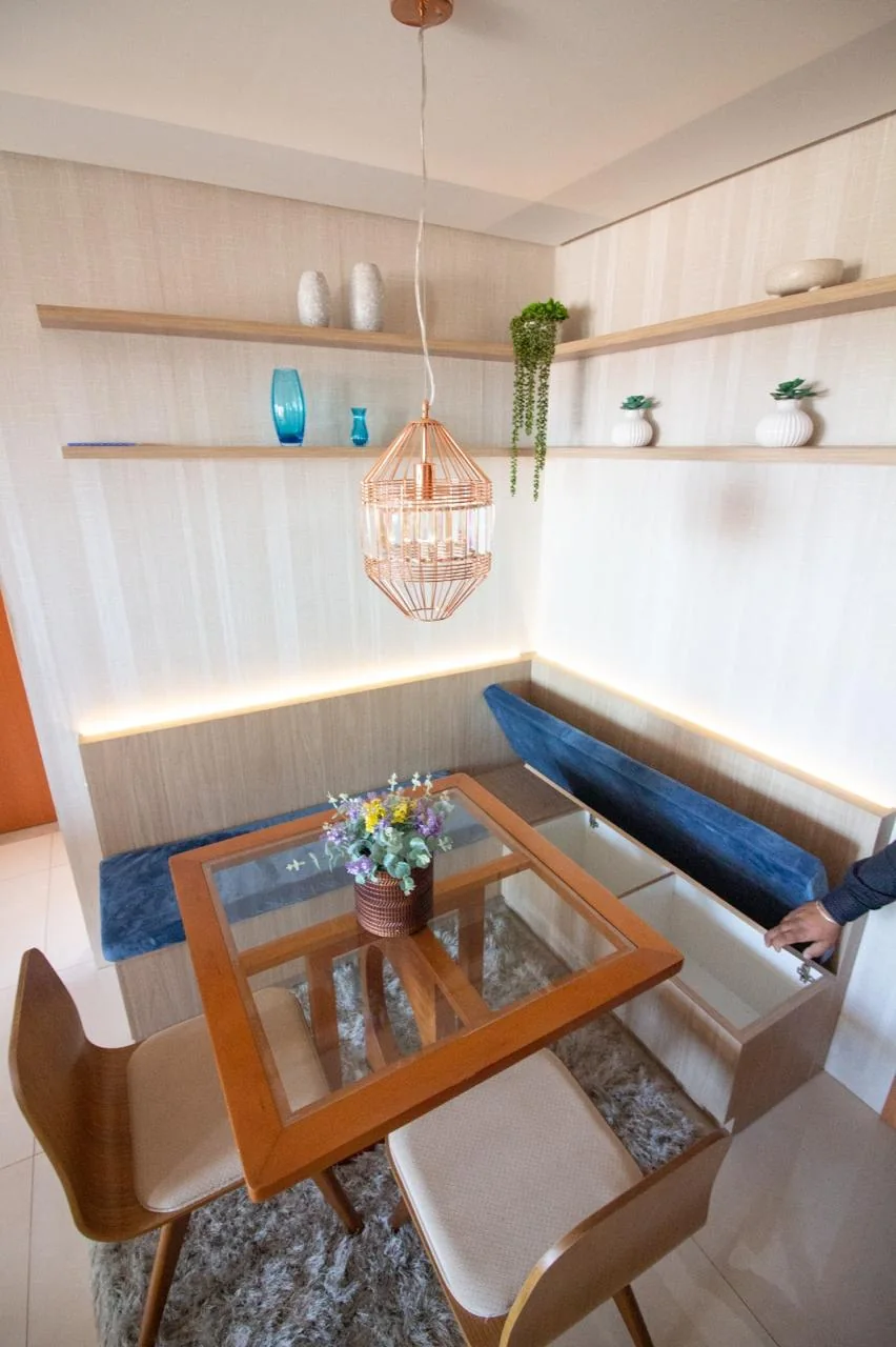 Sala de jantar com canto alemão estofado e prateleiras iluminadas
